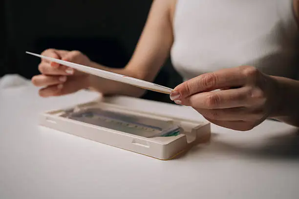 Close-up hands of woman opening screen protector kit