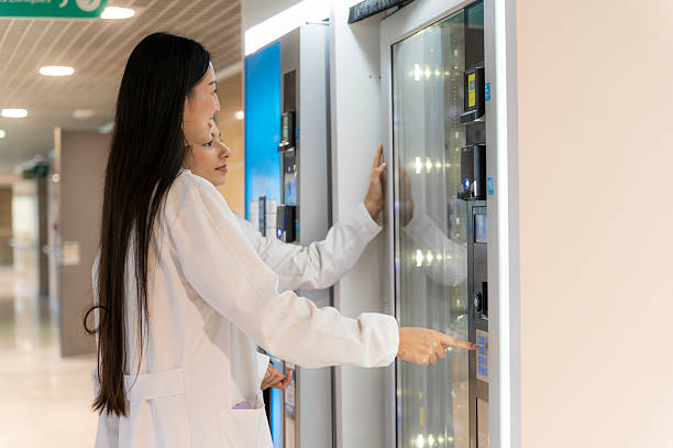 病院の廊下で自動販売機からリフレッシュを見つける女性医師