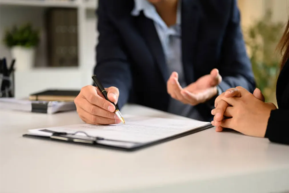 Dos personas de negocios con traje finalizando un importante trato en una oficina moderna