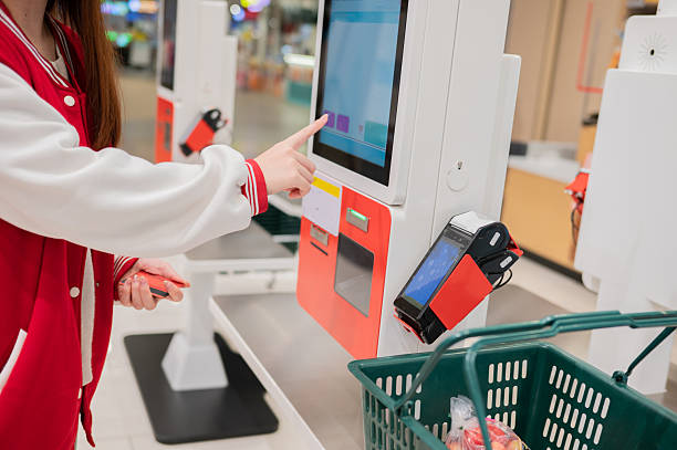 primo piano di mano che effettua il pagamento al self check out toccando lo schermo